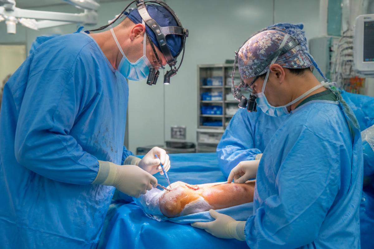 Orthopaedic surgical team operating on a lower limb in a hospital theatre